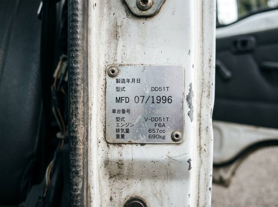 Door-jamb plate on a kei truck showing the month and year of manufacture