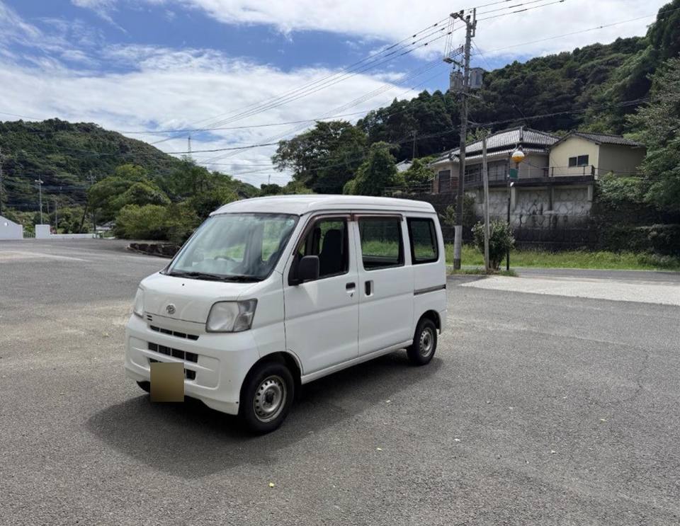 White kei van with the sliding door shut, side view