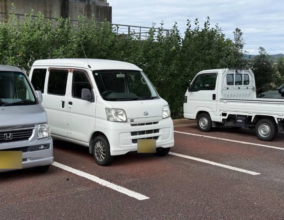 White kei van next to a kei truck in a parking lot